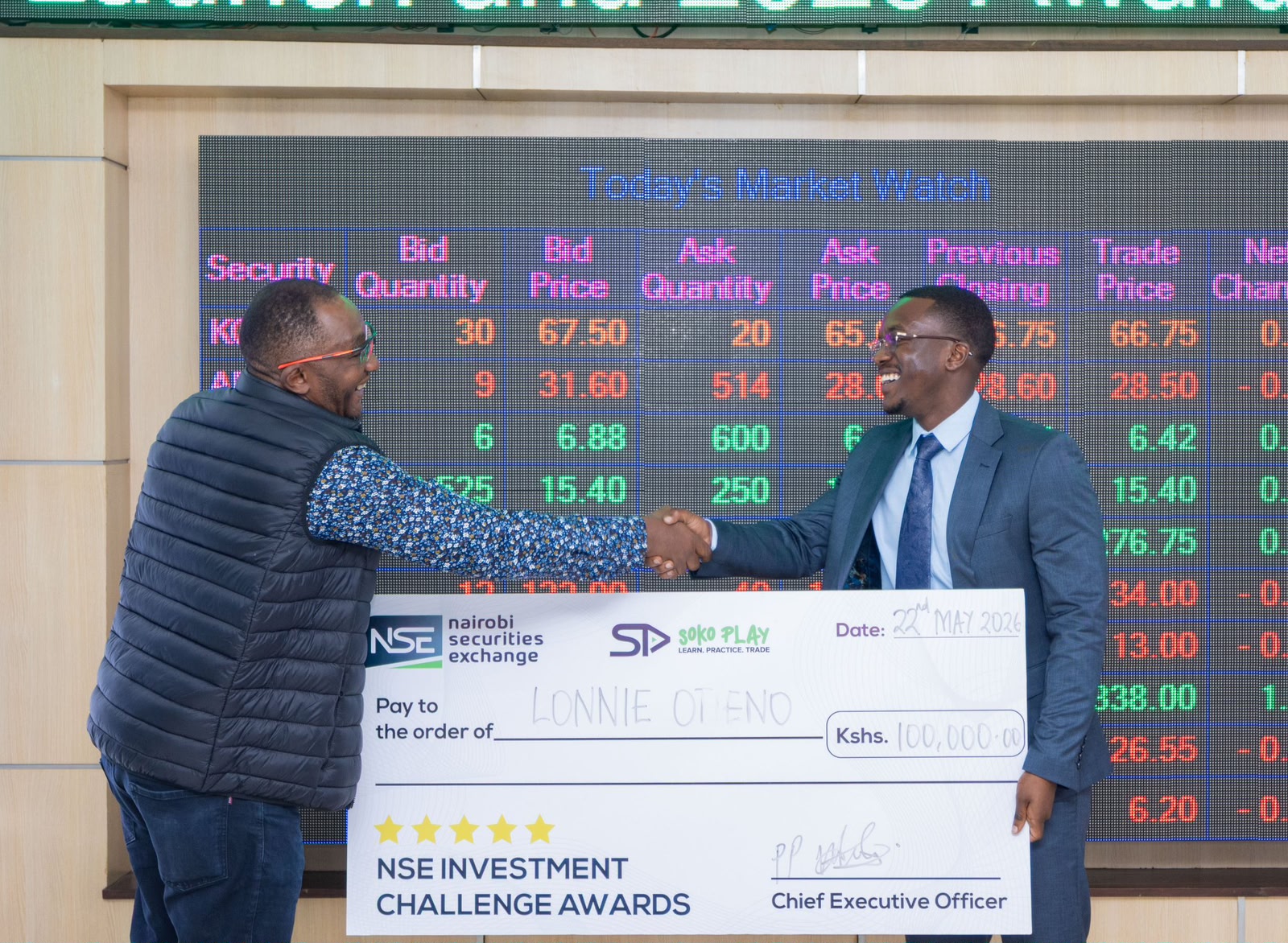 Lonnie Joshua receiving the KES 100,000 cheque on the NSE trading floor